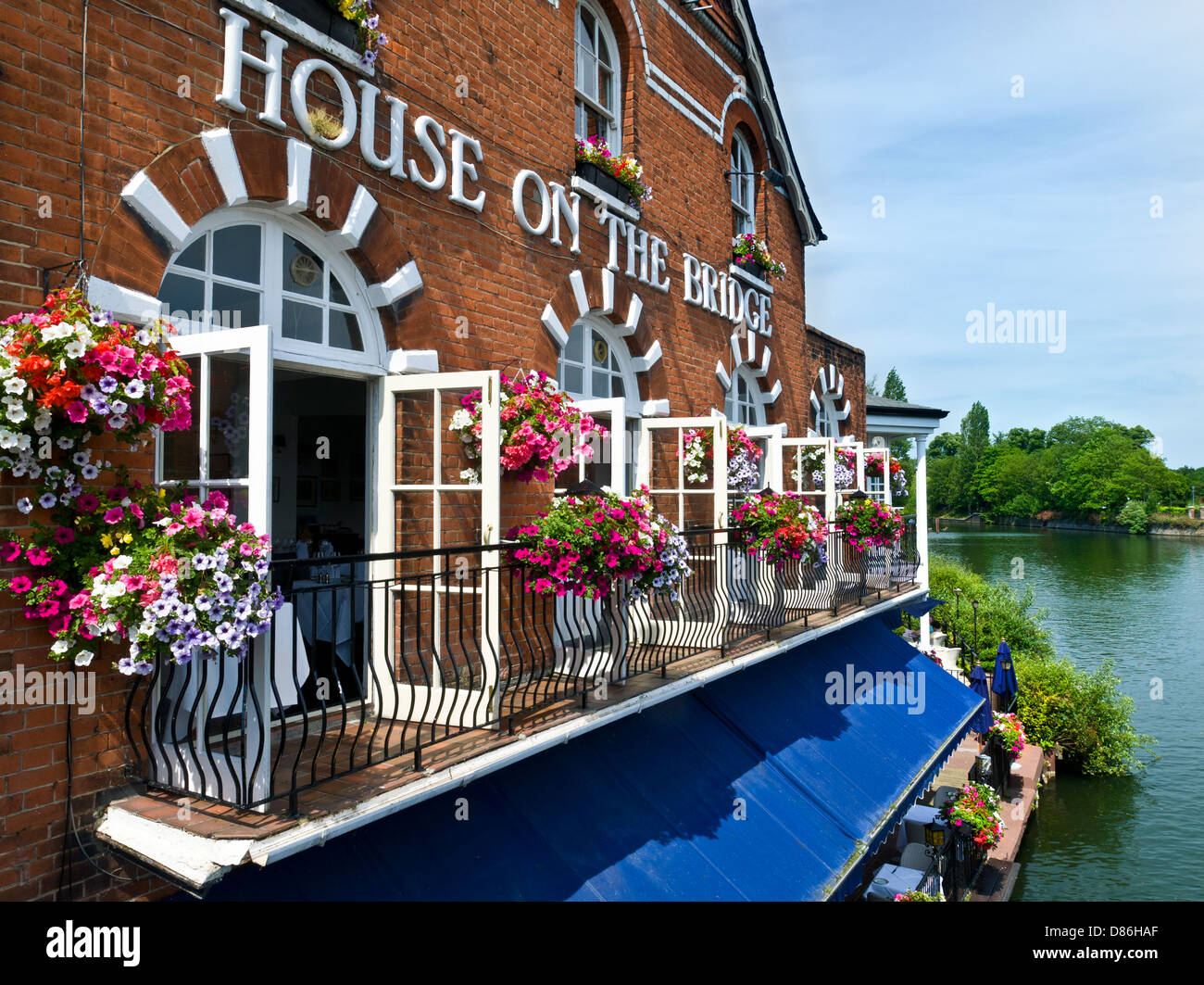 House on the Bridge Restaurant with spring flower baskets from Windsor Bridge over River Thames Eton,Berkshire UK Stock Photo