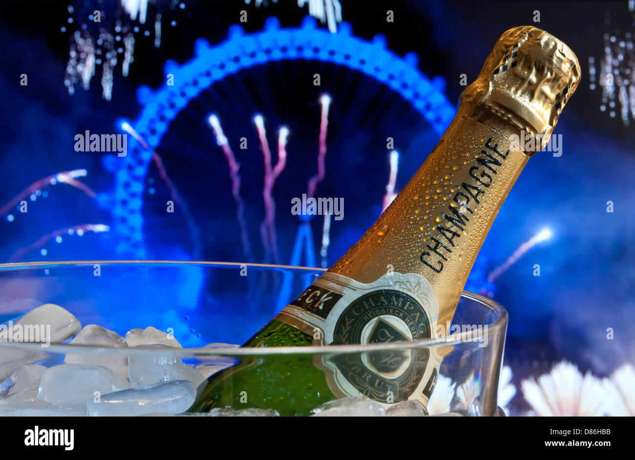 Bottle of champagne on ice in wine cooler with London Eye behind at night with big celebration party fireworks Stock Photo