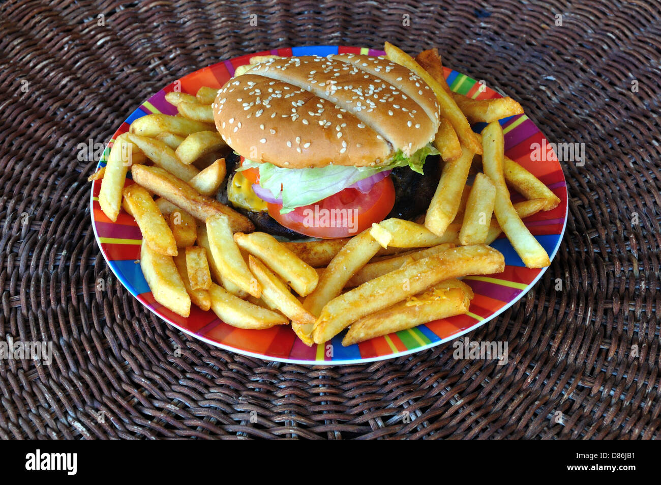 Beef cheeseburger and french fries plate. Fast food background. Stock Photo