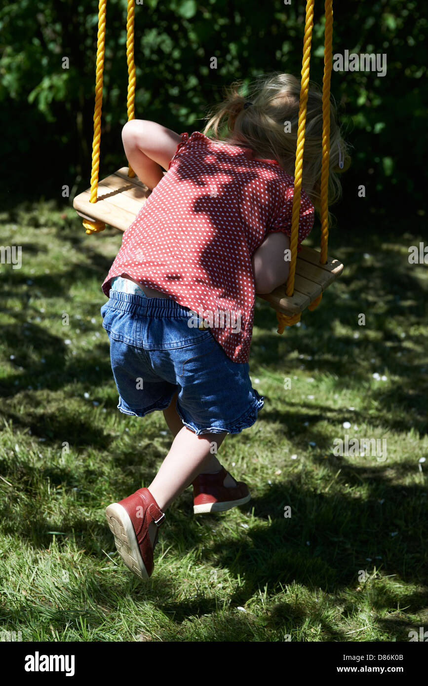 Baby child toddler blond girl on the swing - seesaw - real people Stock Photo