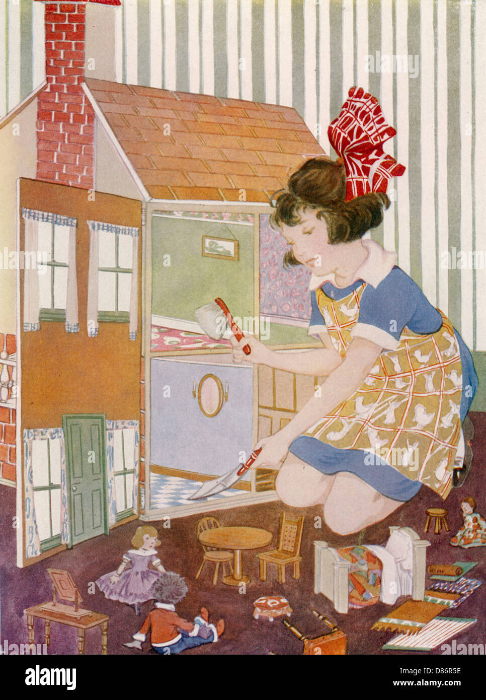 Girl cleaning dolls' house Stock Photo
