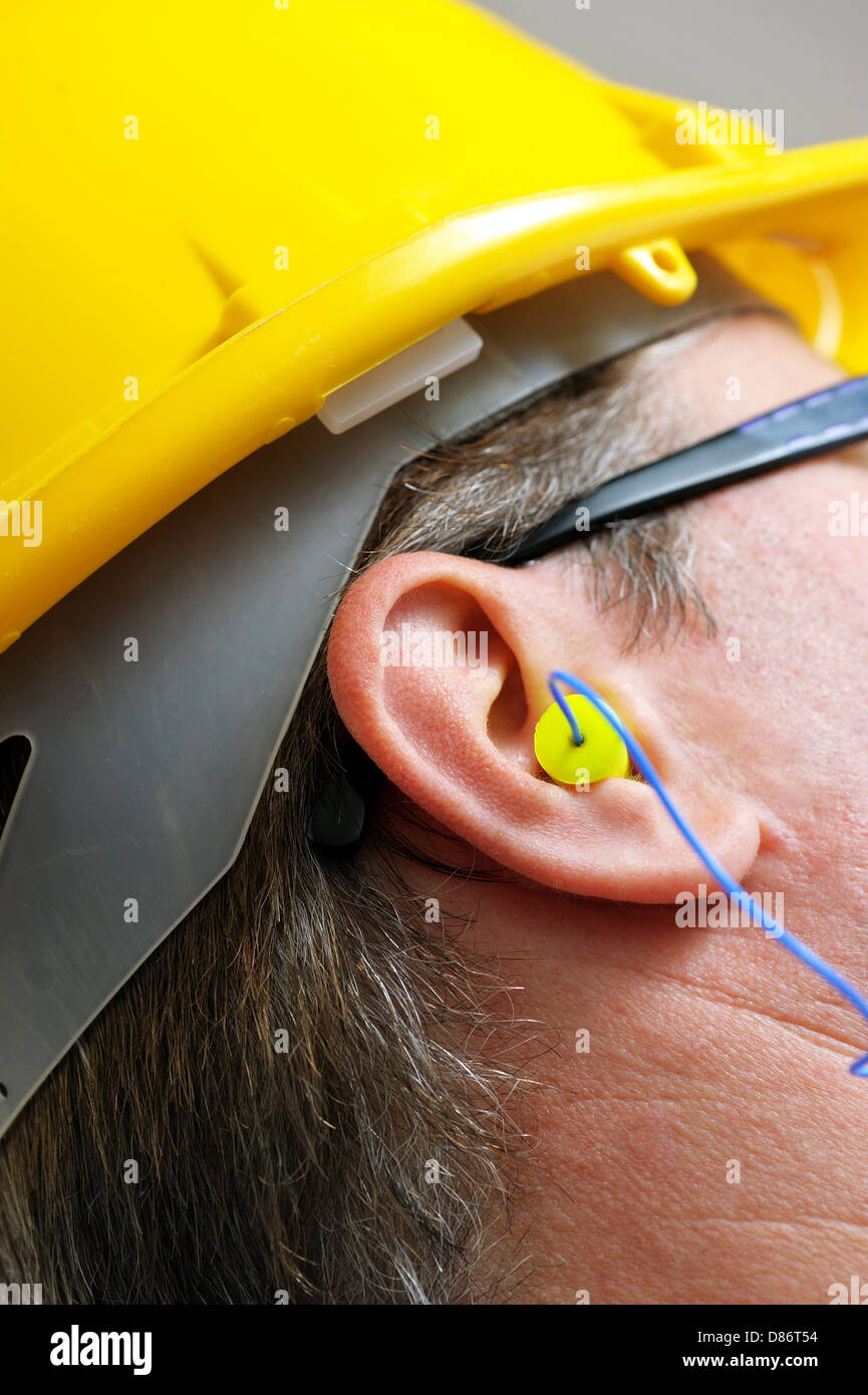 yellow earplug into the ear close up Stock Photo Alamy