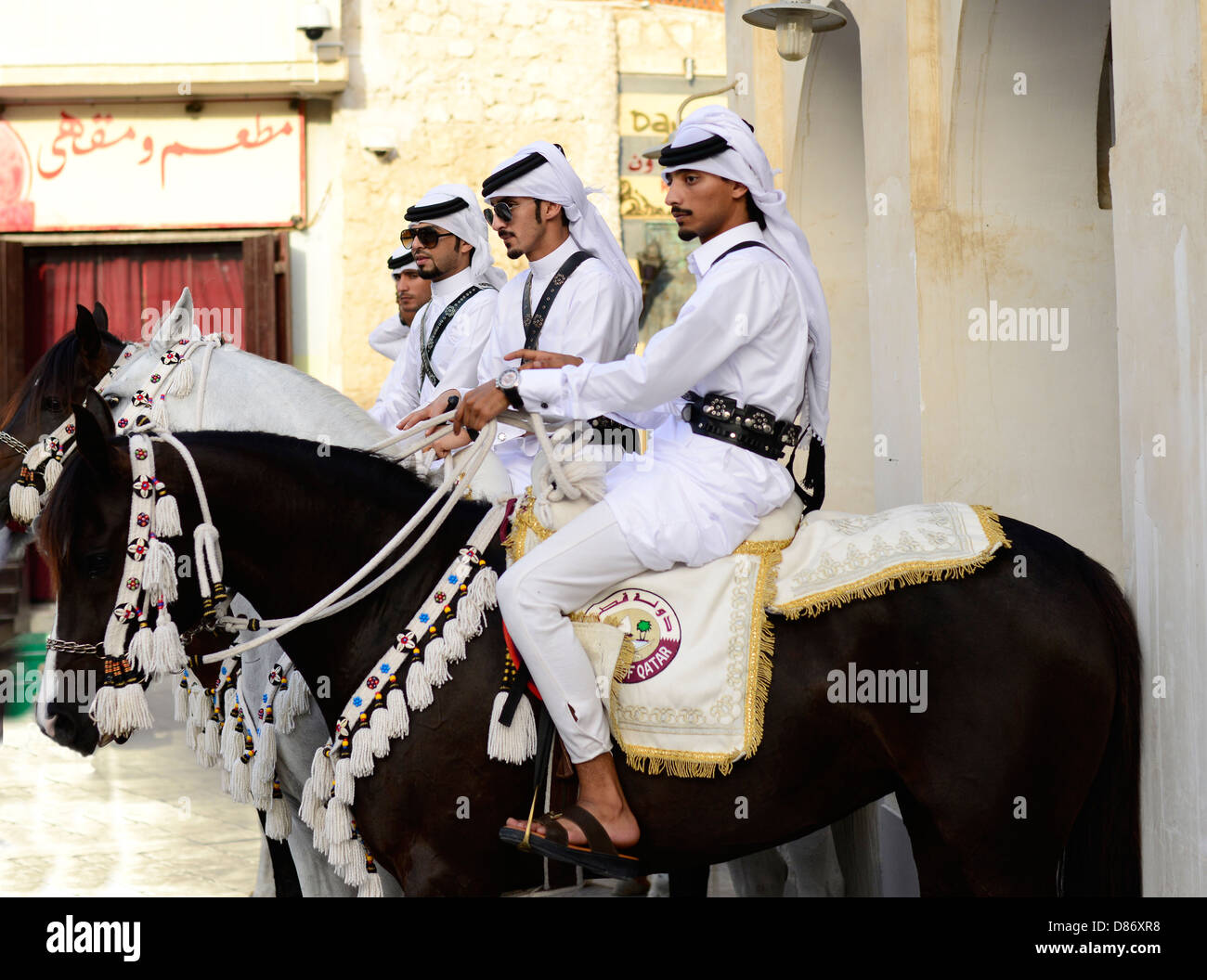 Proud Arab horsemen riding their beautiful Arabian horses in the old souk Waqif in Doha. Stock Photo