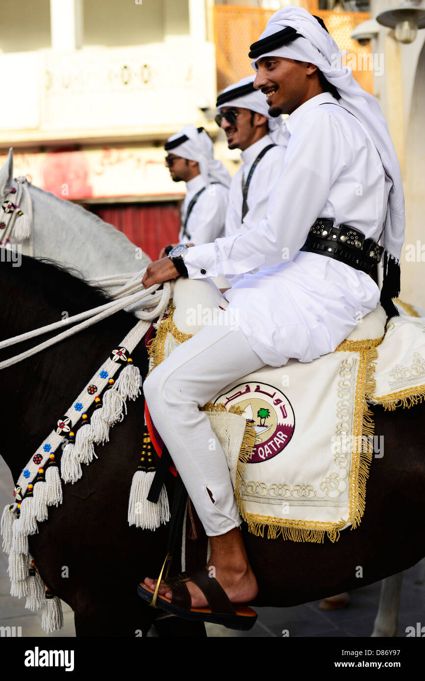 Proud Arab horsemen riding their beautiful Arabian horses in the old souk Waqif in Doha. Stock Photo