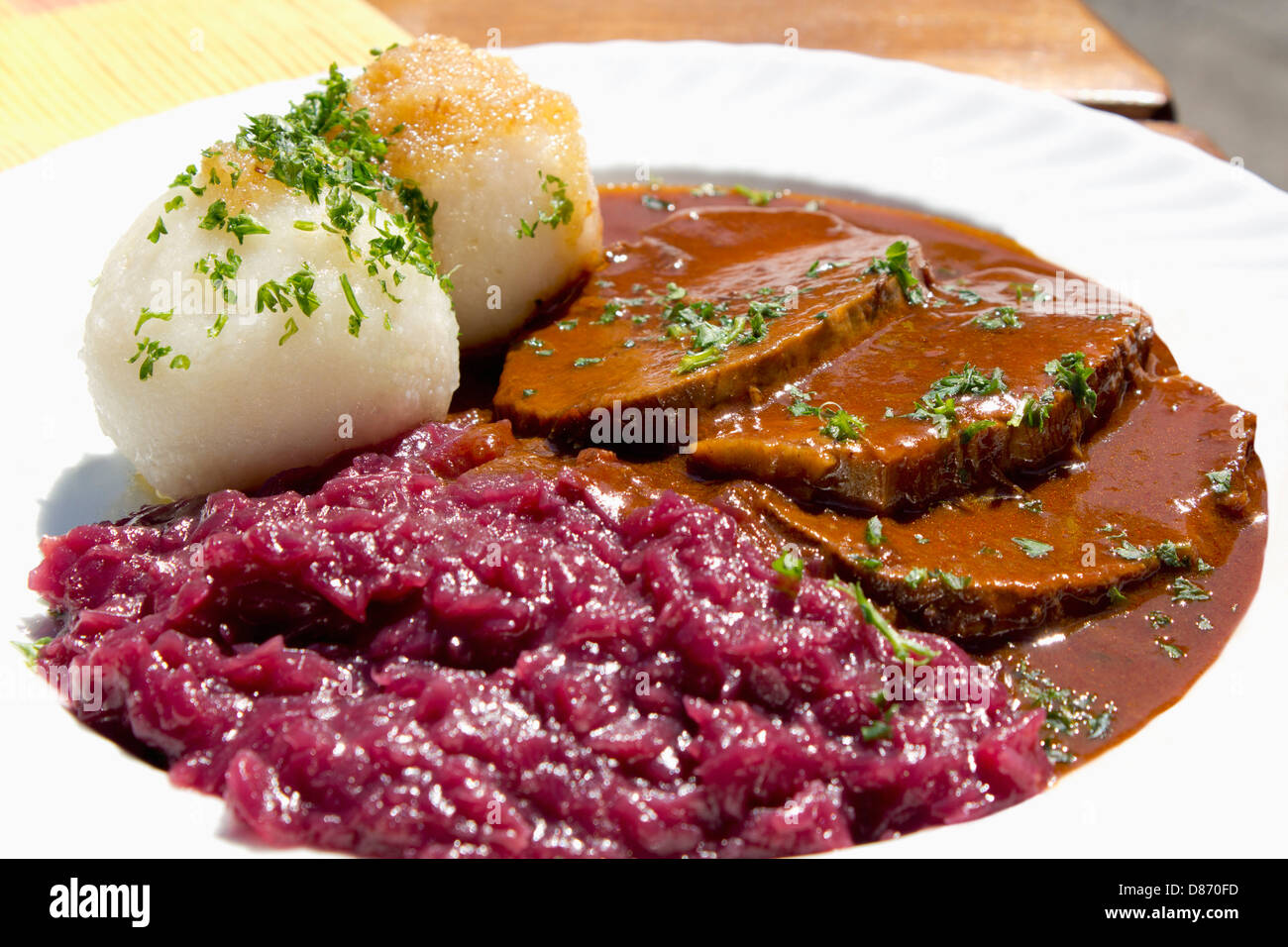 Plate of sauerbraten marinated beef with red cabbage and potato