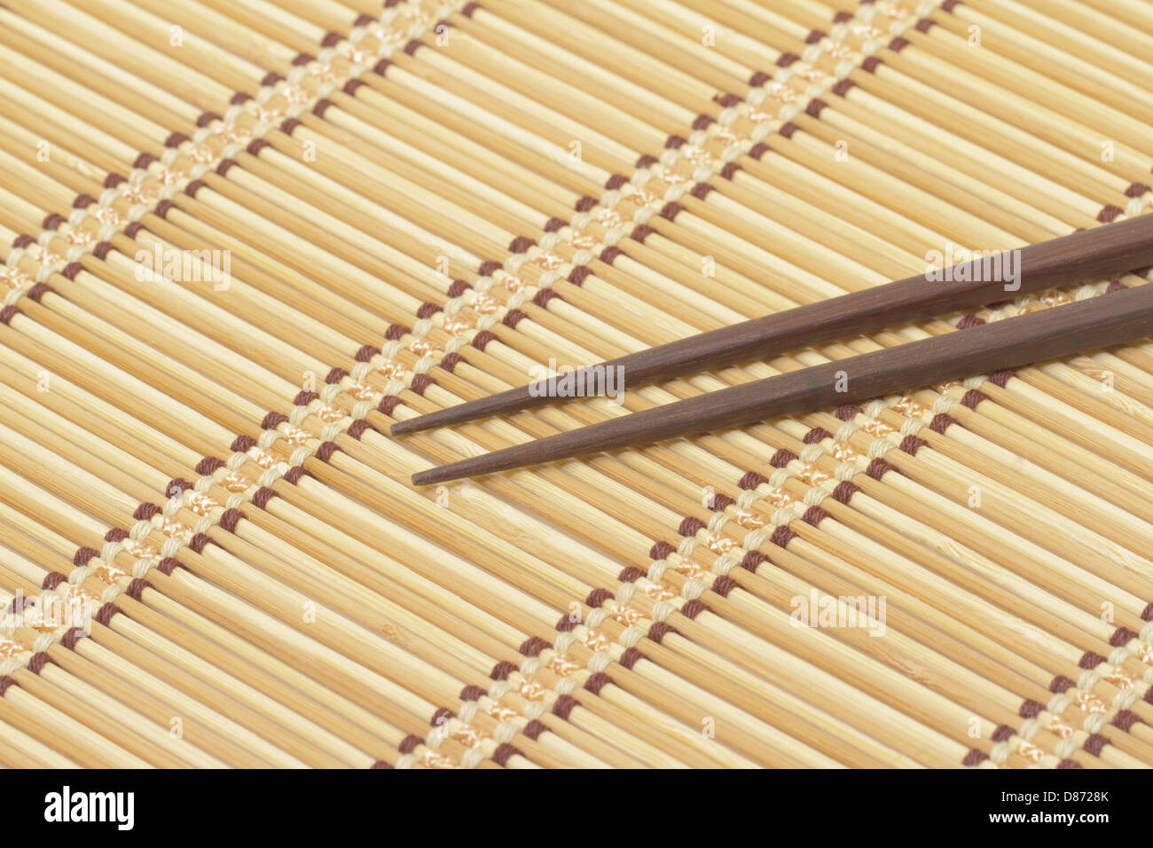 chopsticks and sushi roll on bamboo mat. background menu Stock Photo - Alamy