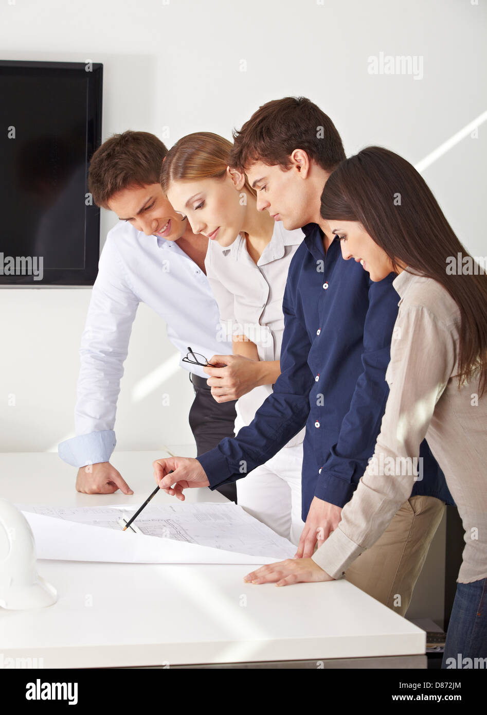 Architects team working on construction drawing in their office Stock Photo