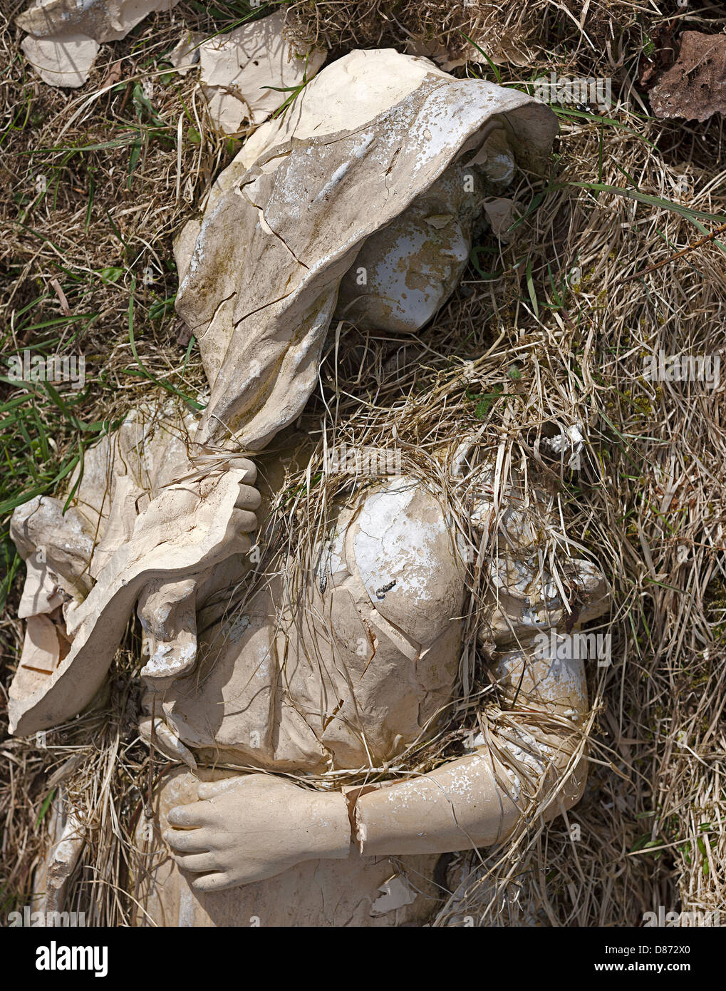 Statue of young lady broken through high winds. Statue laying in grass. Stock Photo