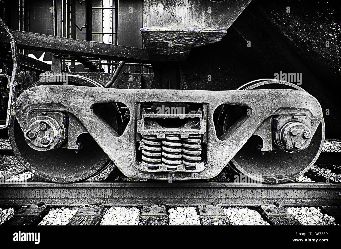 This is a black and white closeup image of train locomotive engine wheels. Stock Photo