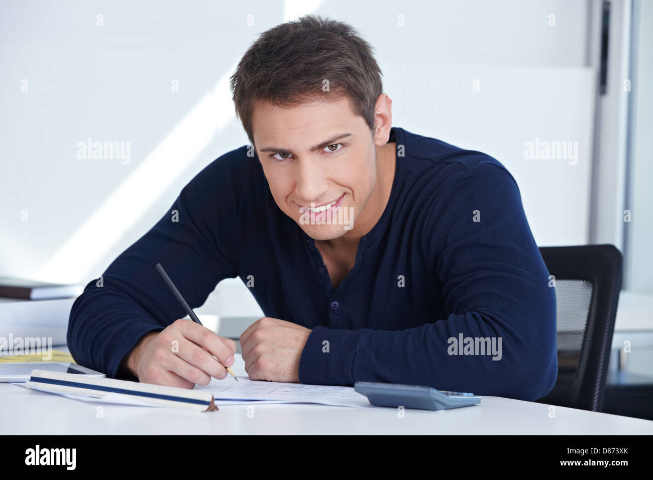 Architectural draftsman working at his desk in the office on a blueprint Stock Photo