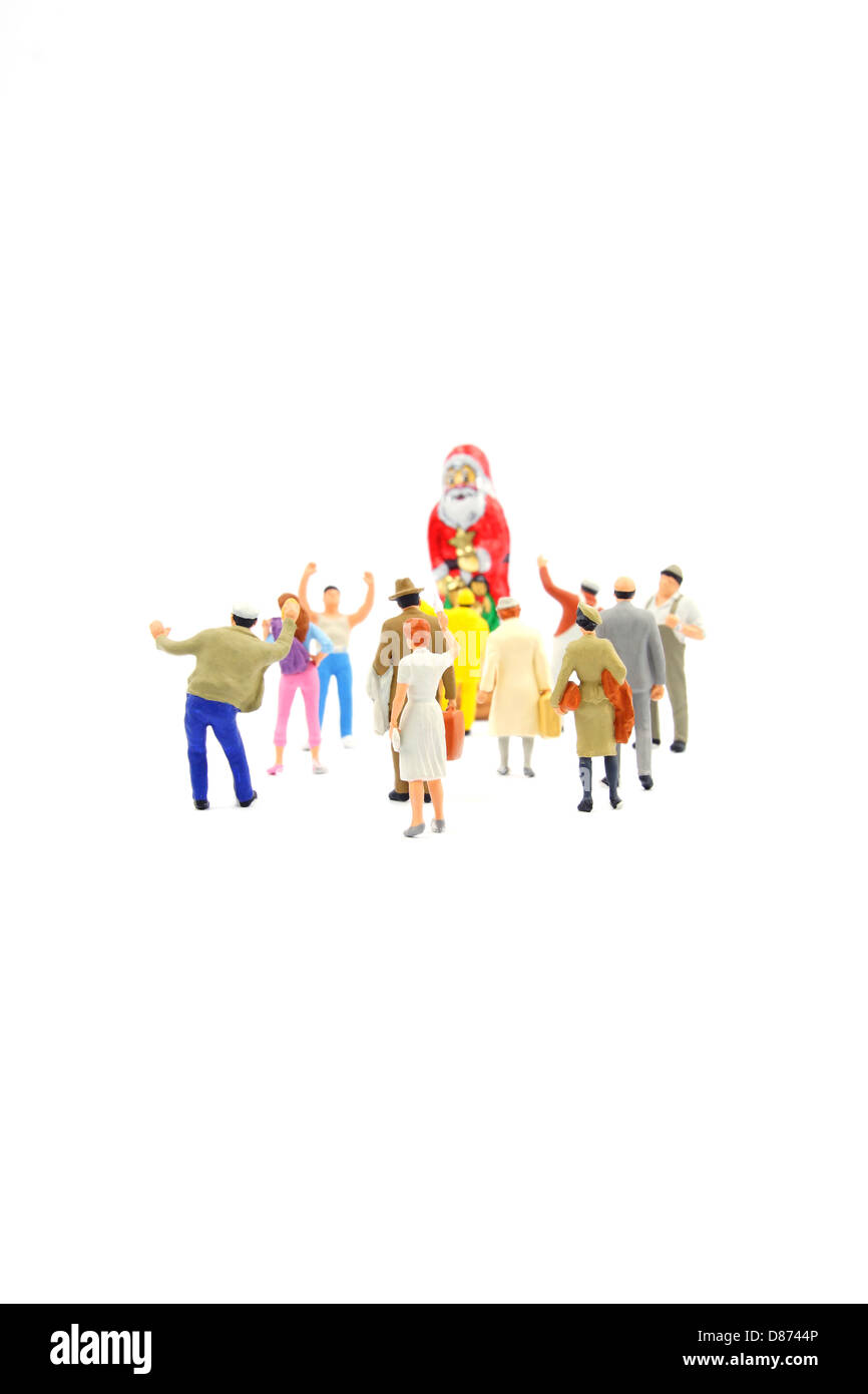 Crowd of miniature figurines fascinated by santa claus Stock Photo