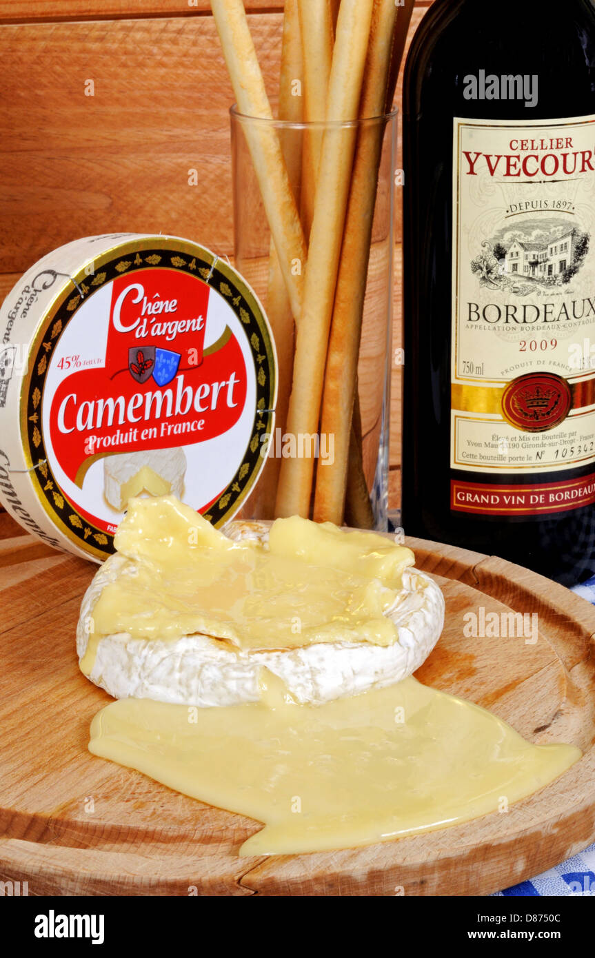 Baked whole French Camembert with Grissini breadsticks and a bottle of red  wine Stock Photo - Alamy