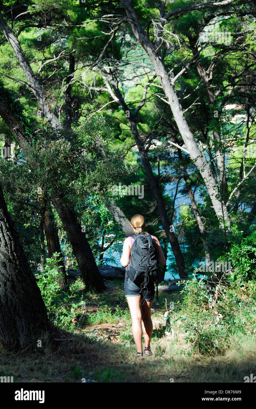 LYCIA, TURKEY. A young woman walking along a forest track on the Lycian Way near Kalkan. 2010. Stock Photo