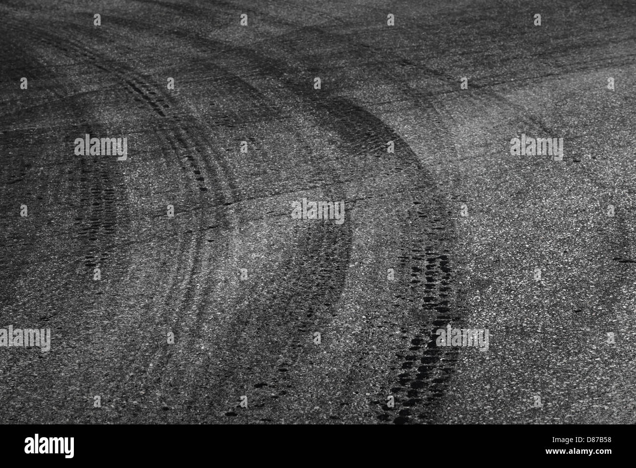 Dangerous turn. Abstract road background with tires tracks on dark asphalt Stock Photo