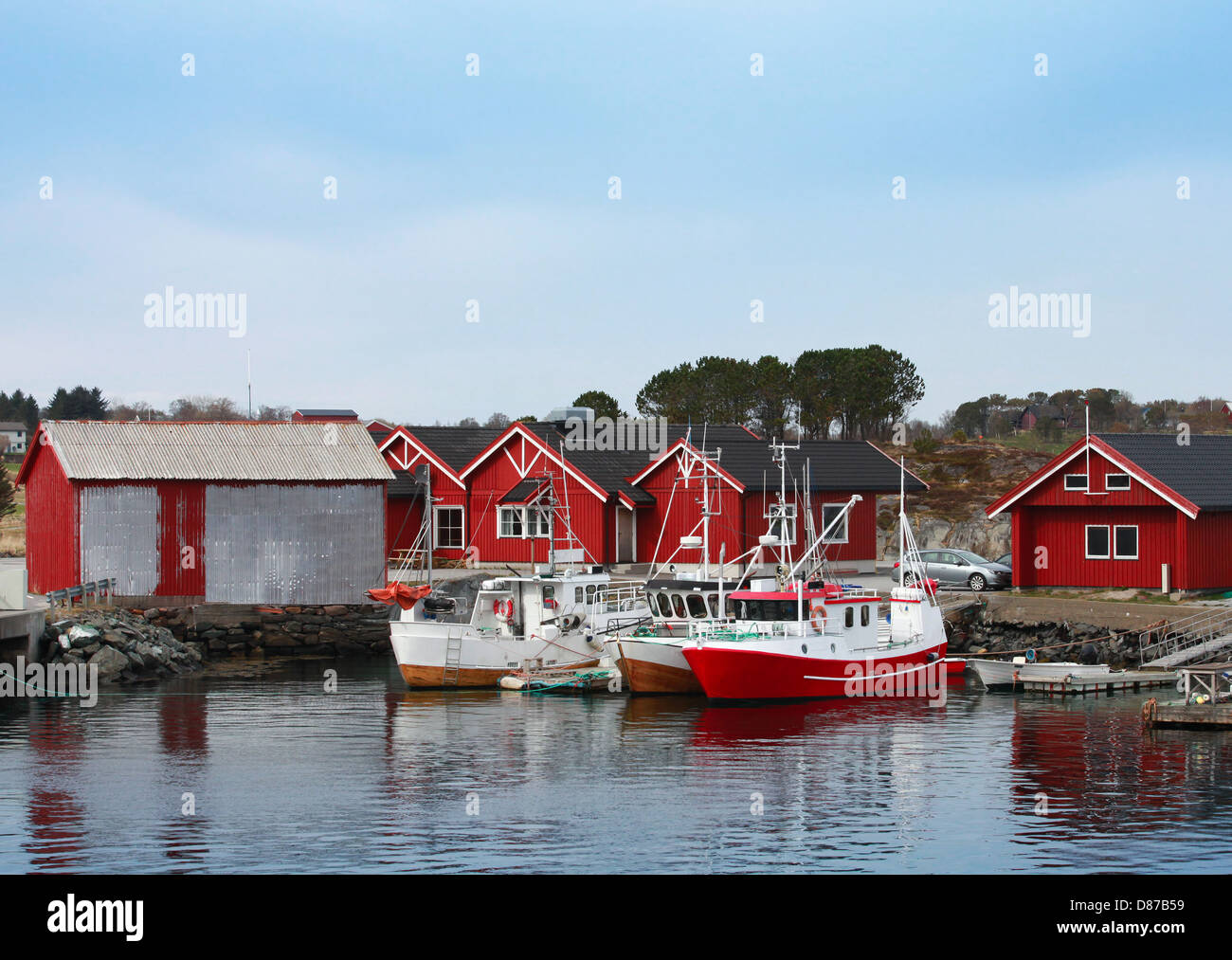 Norwegian fishing village with red wooden houses and small boats on the ...