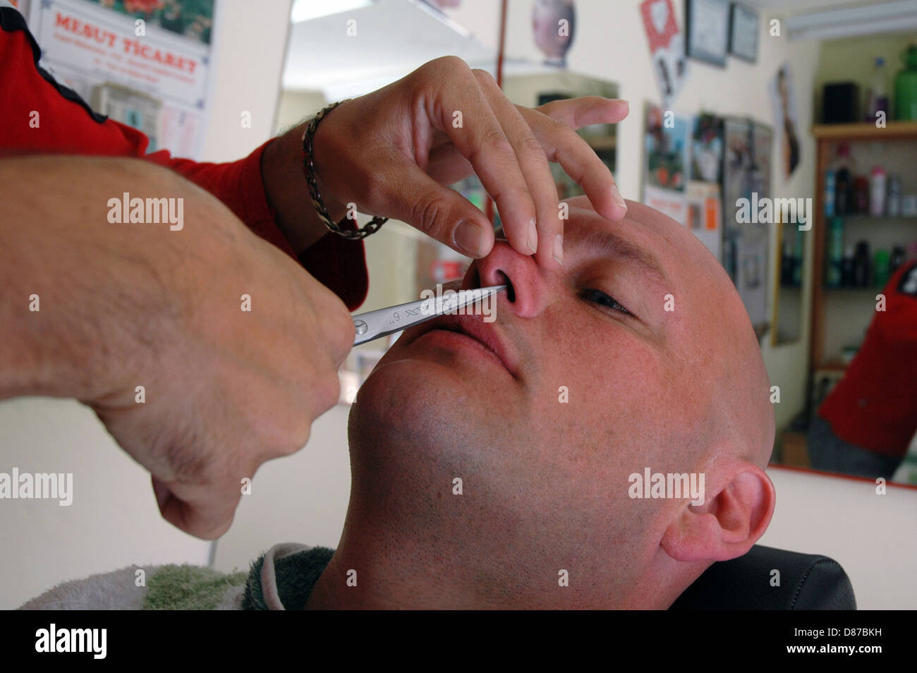 Barber shaving and grooming men in Turkish village barber shop Stock
