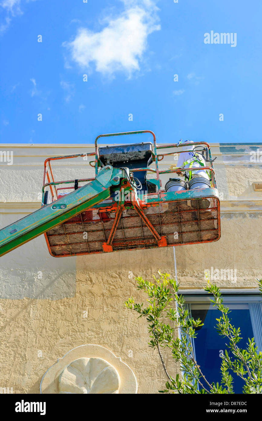 Painters in a cherry picker paint the outside of a building in downtown Sarasota Stock Photo