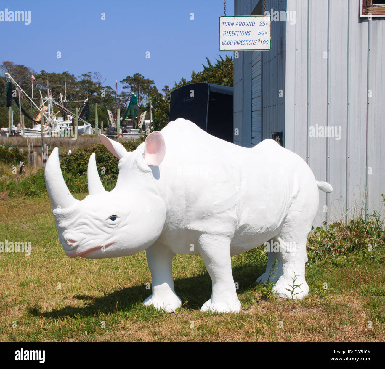 A large white rhinoceros sculpture stands proudly in Sea Level, North Carolina, blending wildlife art with coastal charm. Stock Photo