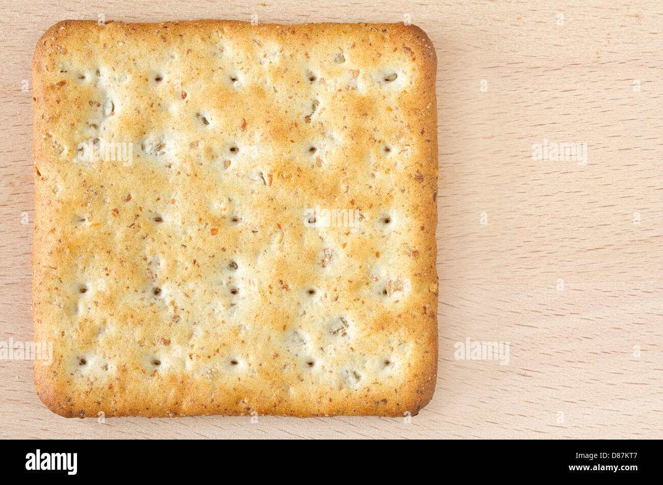 One wholegrain cracker on wooden board Stock Photo