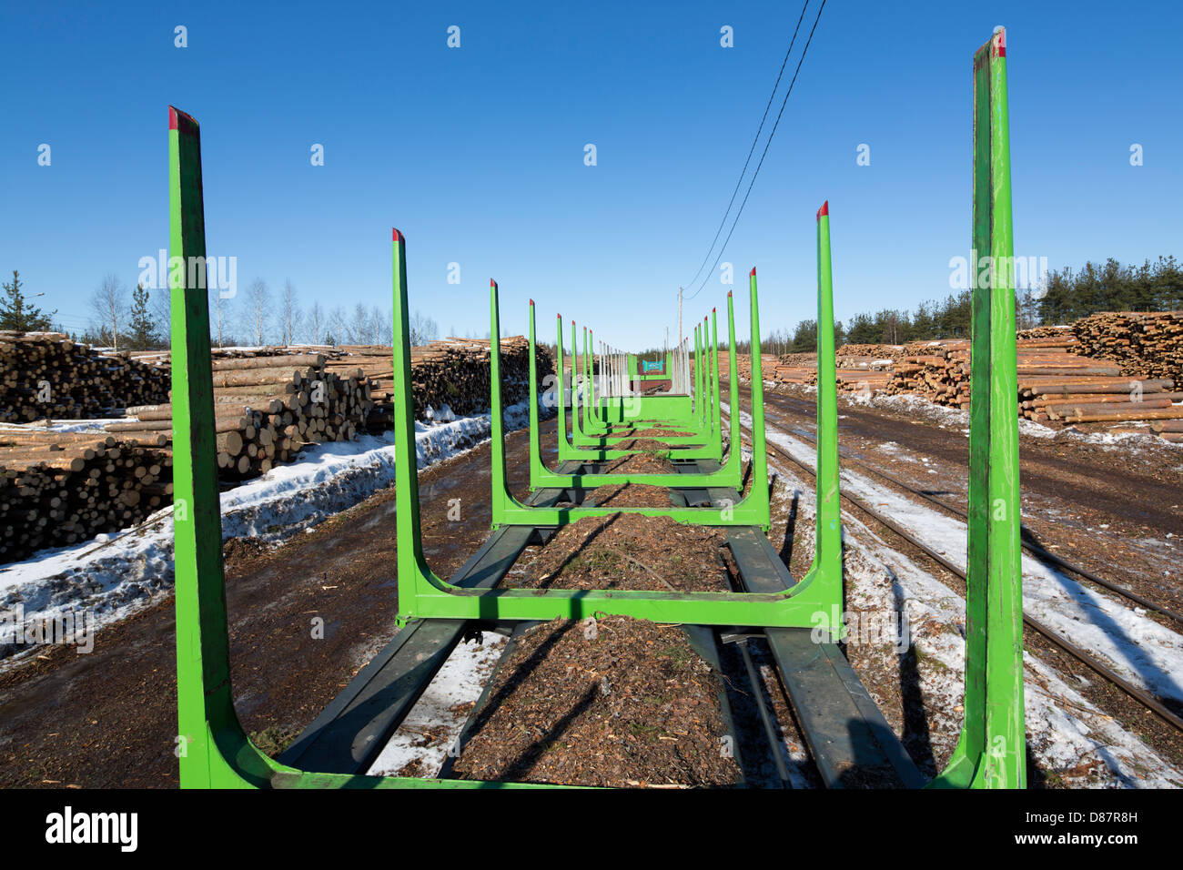 View of railroad depot for log transport and storage , log piles and