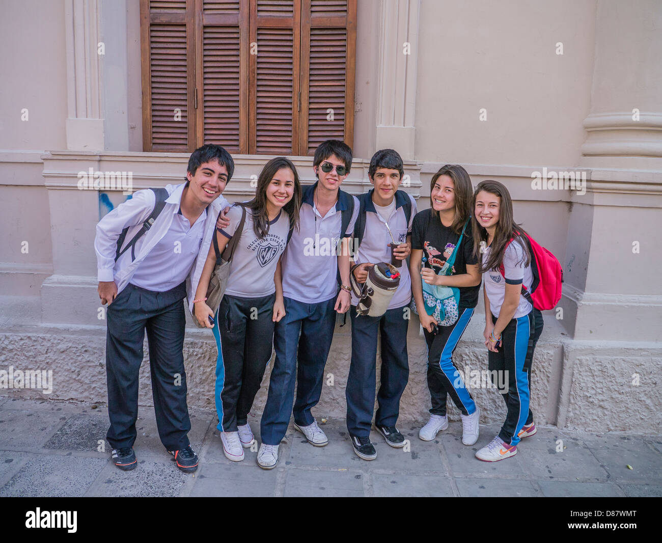A group of teenage high school students, boys & girls, smile & face forward as they gather outside of their school in Asunción. Stock Photo