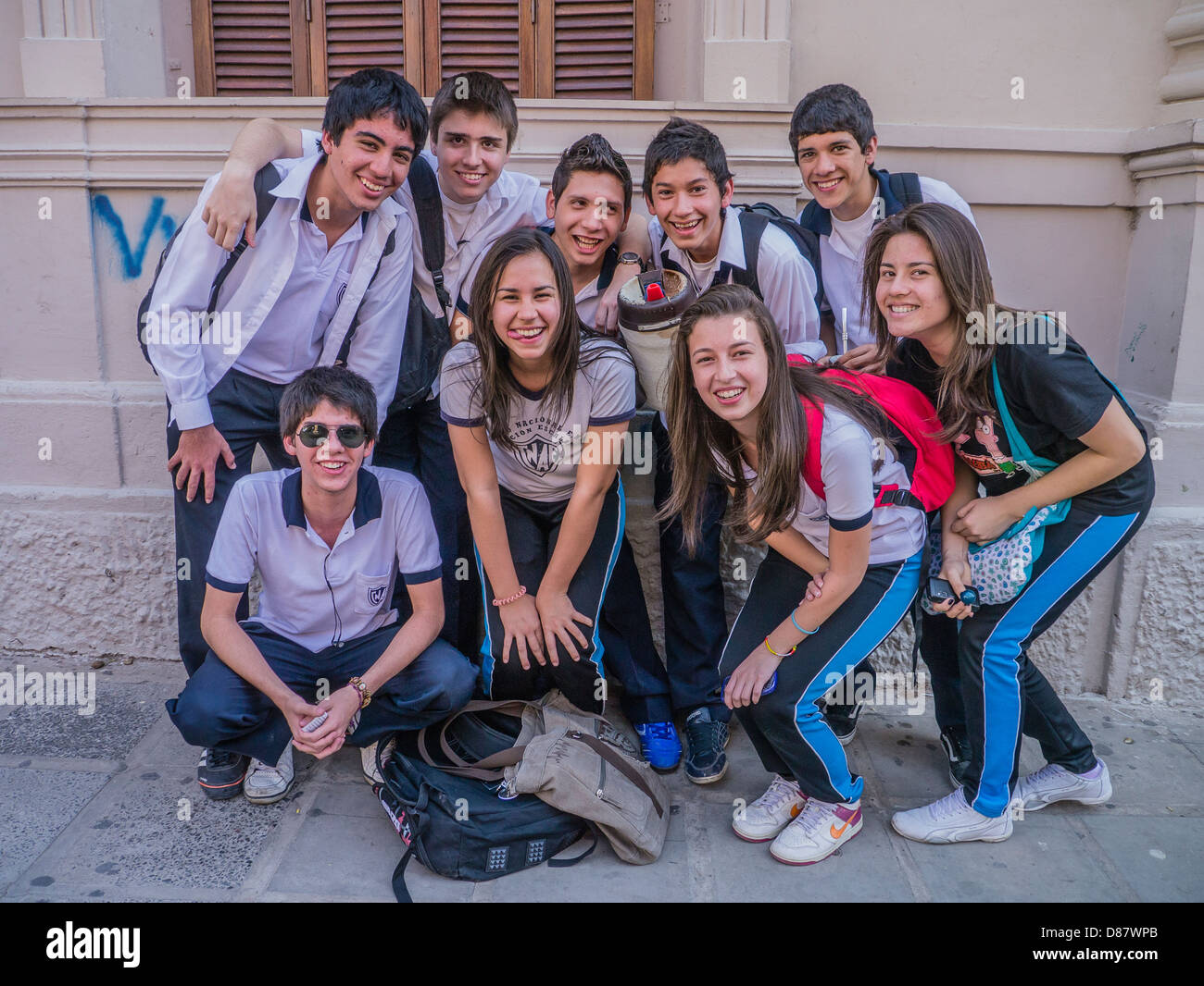 A group of teenage high school students, boys & girls, smile & face forward as they gather outside of their school in Asunción. Stock Photo