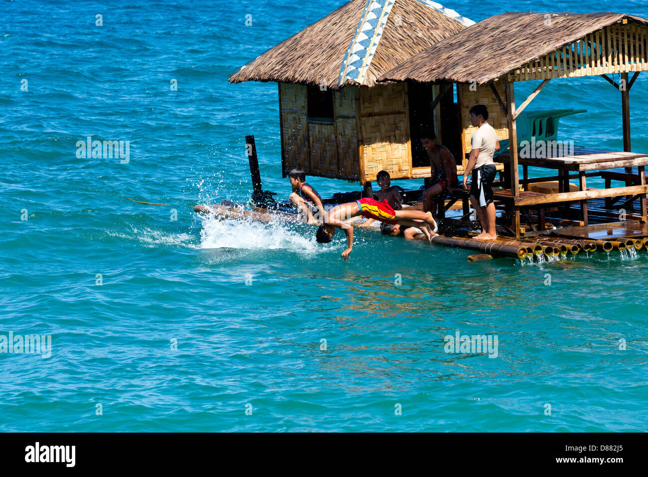 Children jumping from a floating House in the Ocean on Mindoro Island