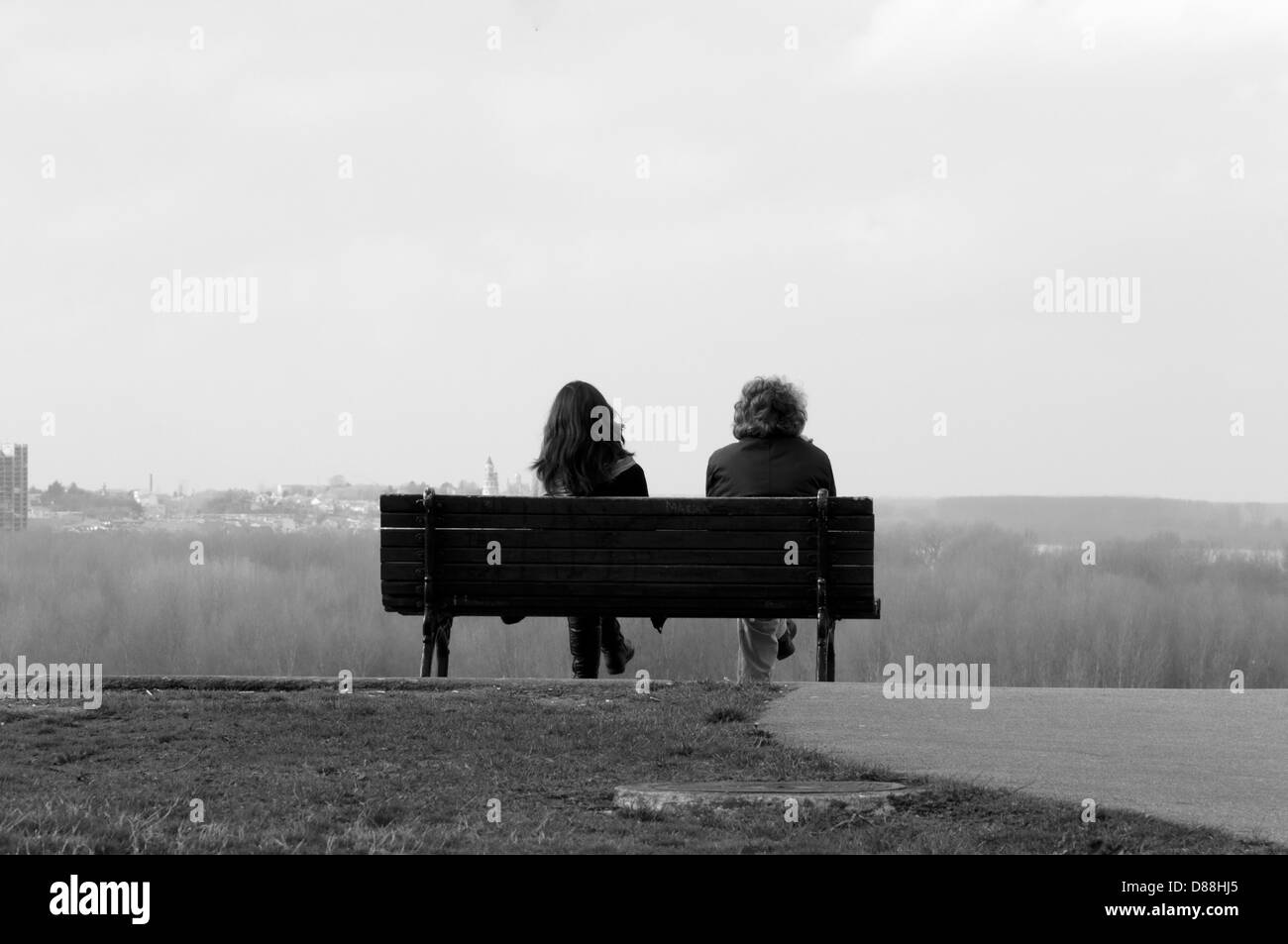 Two people sitting on bench in black and white Stock Photo