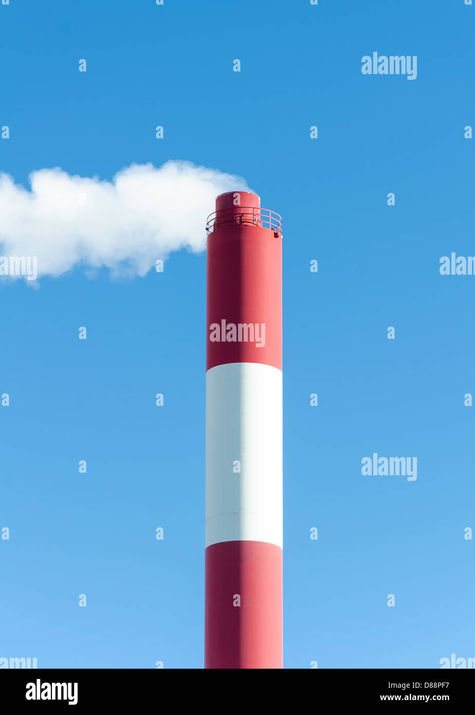 Industrial chimney with smoke over blue sky Stock Photo - Alamy