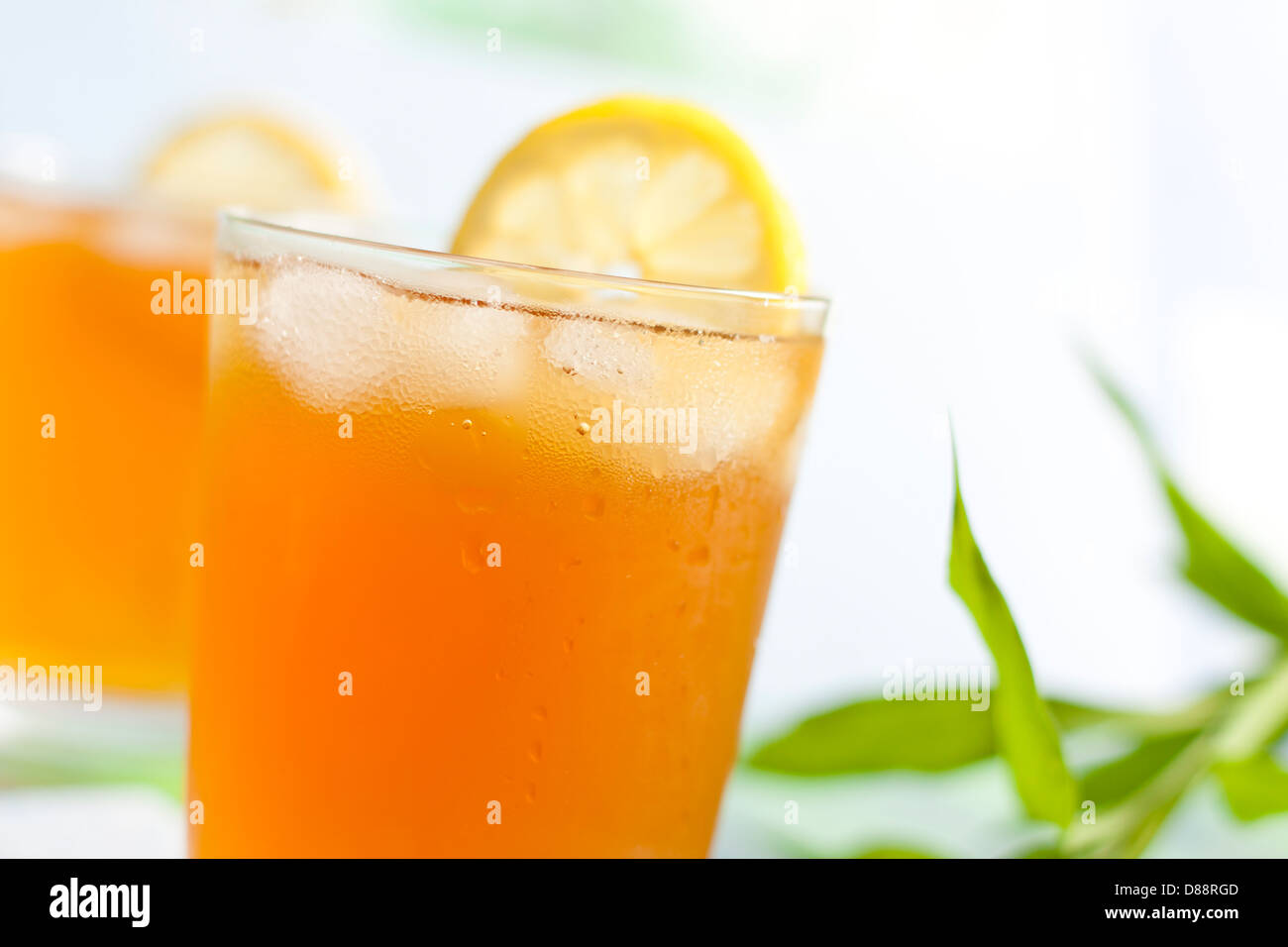 Glass of ice tea with lemon on blurred background Stock Photo