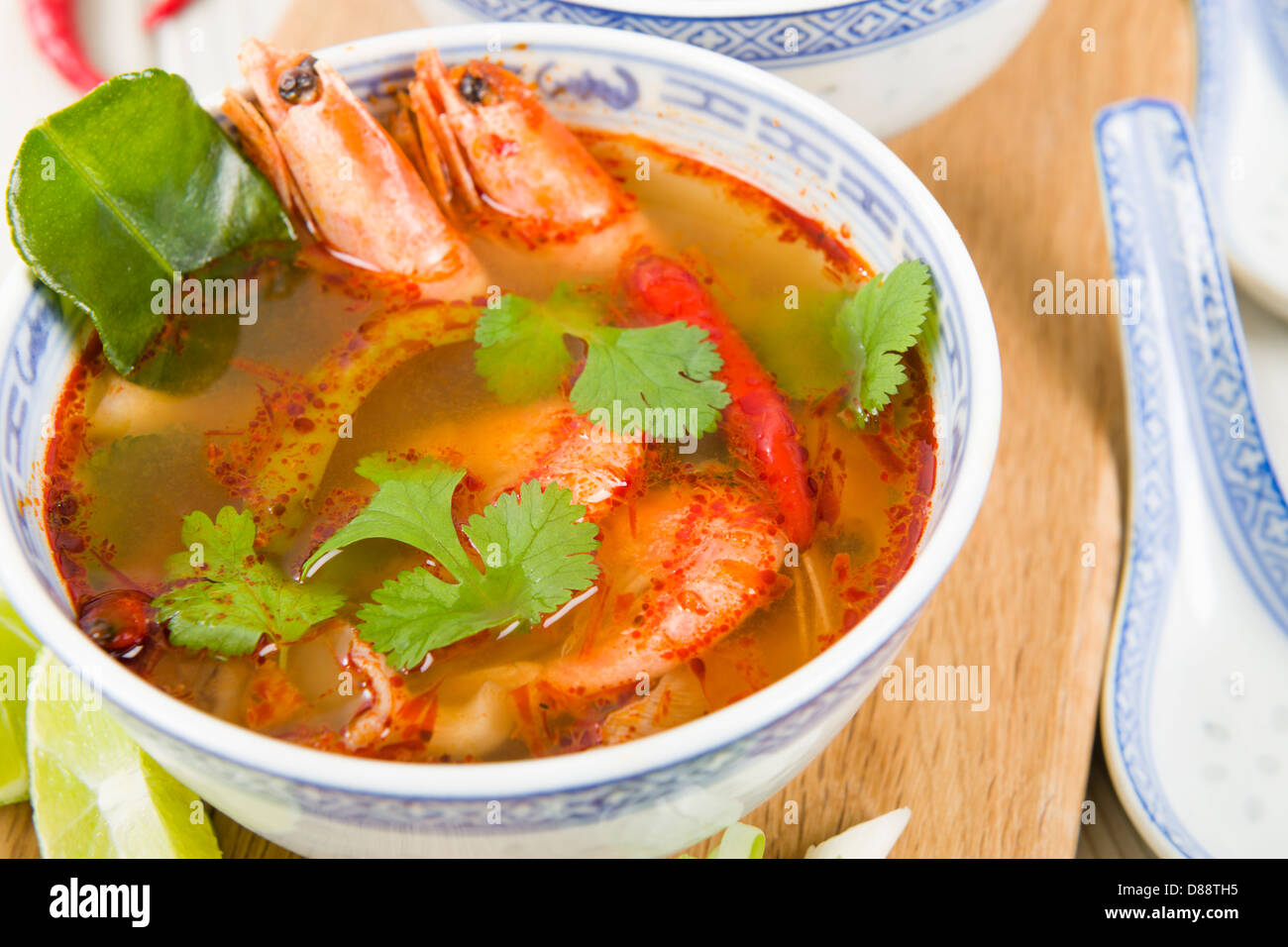 Tom Yum Goong - Thai clear hot and sour soup with king prawns and oyster  mushrooms served with lime wedges Stock Photo - Alamy