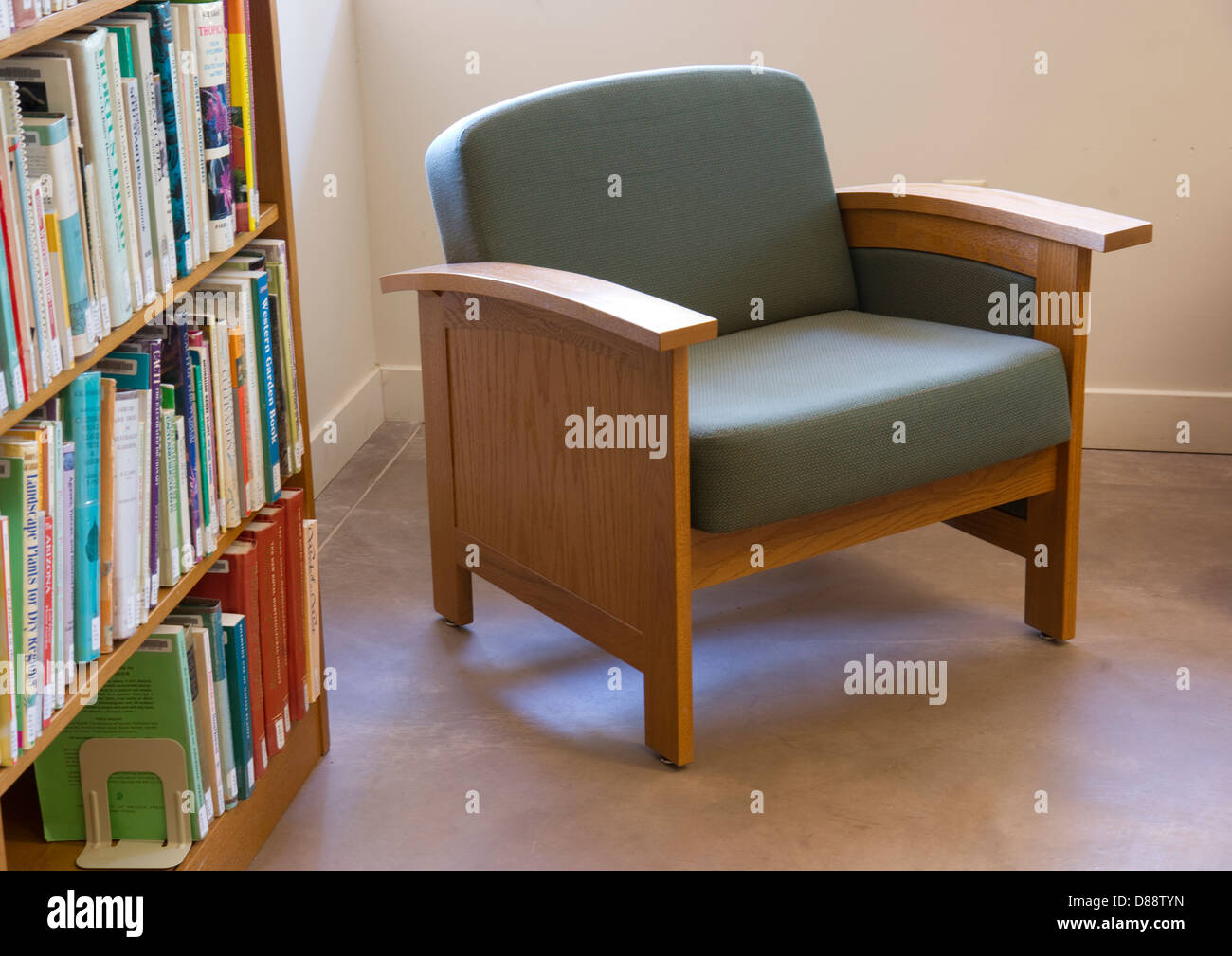 Row of books on a shelf next to seating area in the library Stock Photo