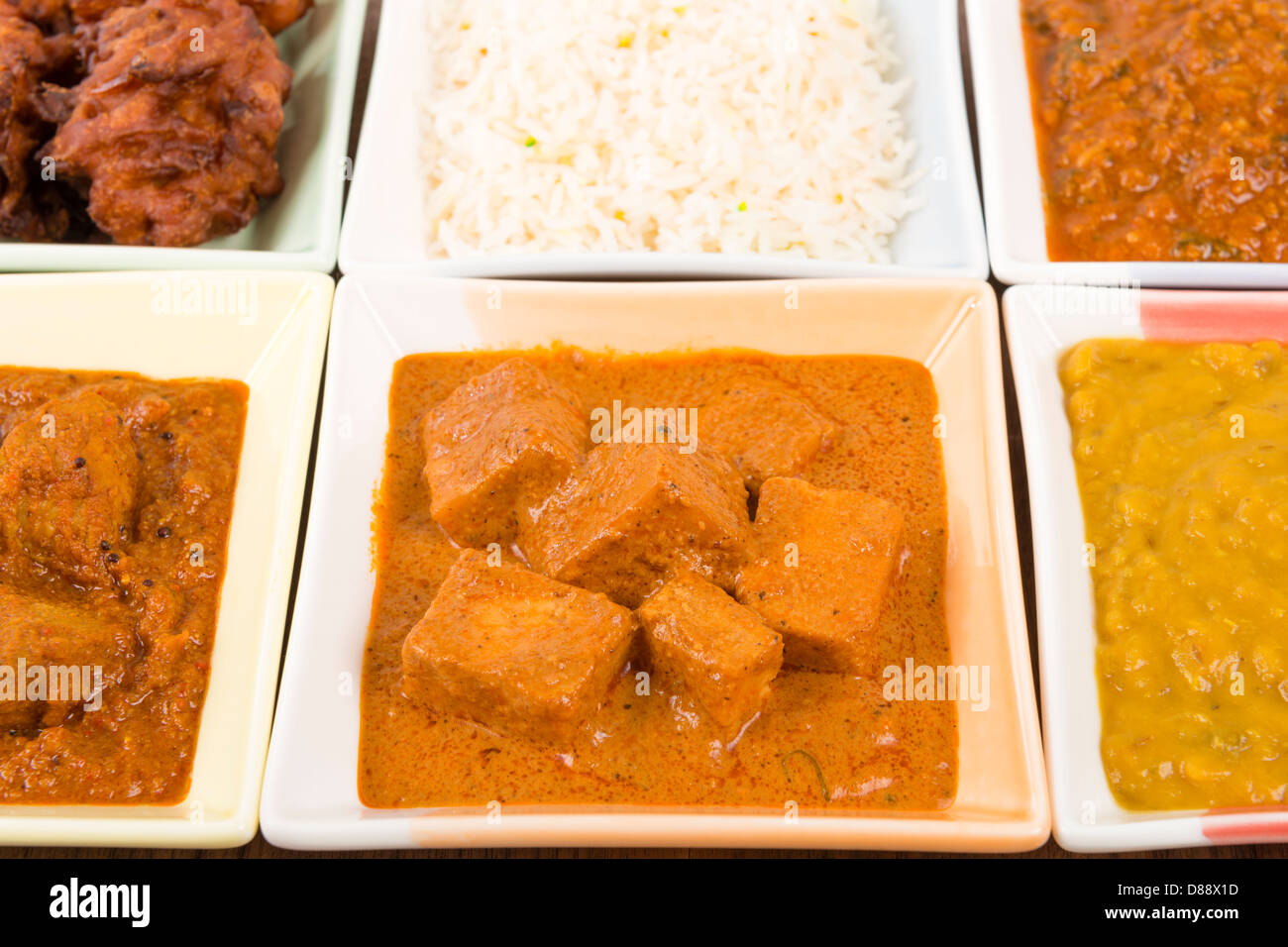 Thali - Indian meal set with vegetarian and meat curries, pilau rice and onion bhajis. Stock Photo