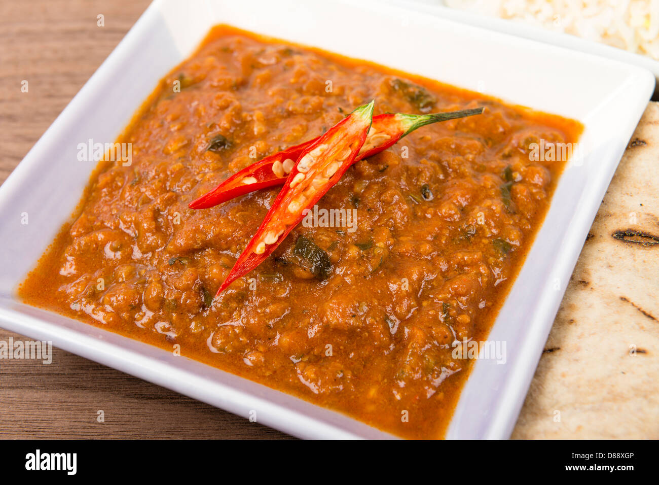 Keema Madras - Minced lamb curry garnished with chilies and served with rice and chapatis. Stock Photo