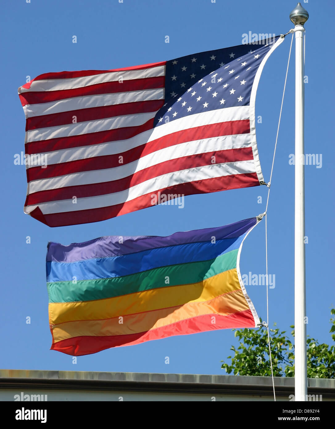 An American and a gay pride flag waving in the wind Stock Photo