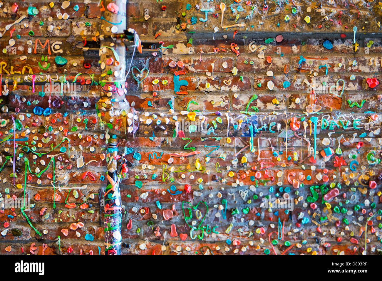 Brick wall and piping, covered with used bits of chewing gum at Pike Place Public Market in Seattle, Washington, USA Stock Photo