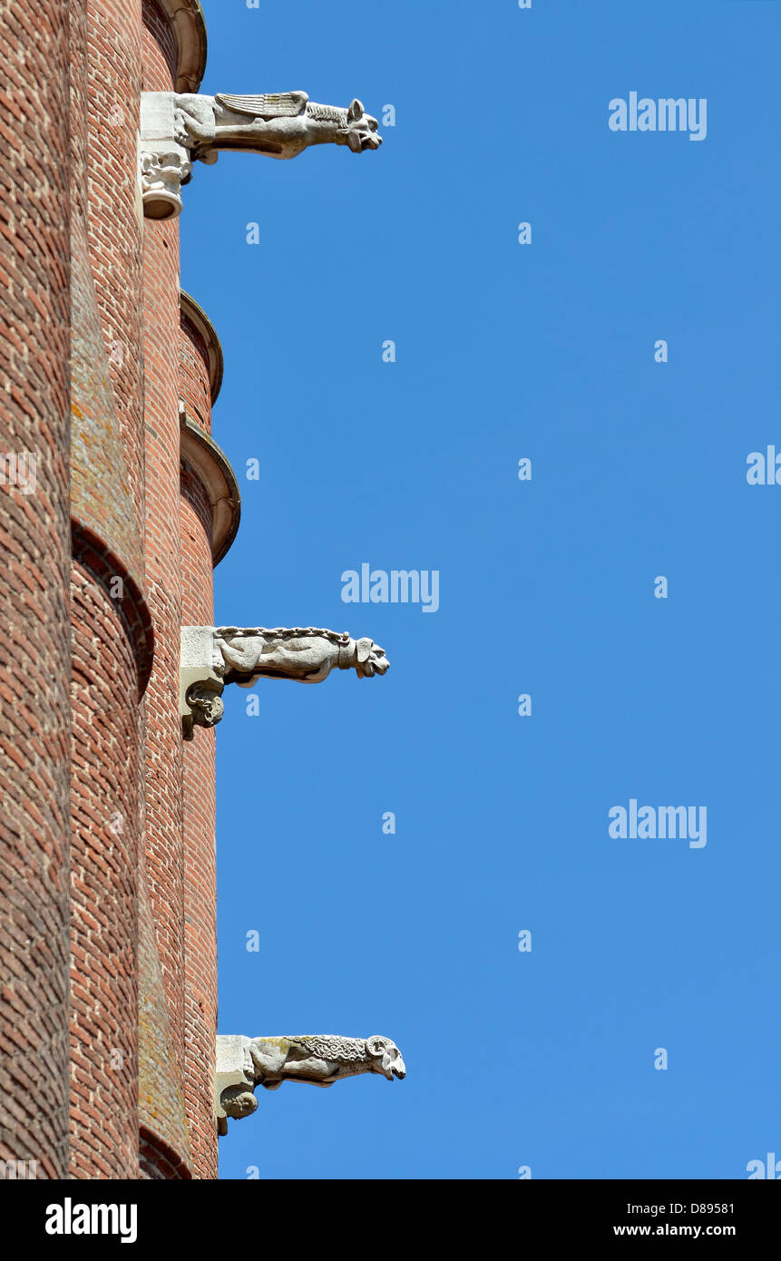 Three gargoyles on the blue sky background, of the Sainte Cécile cathedral made in red bricks at Albi in southern France, Midi P Stock Photo