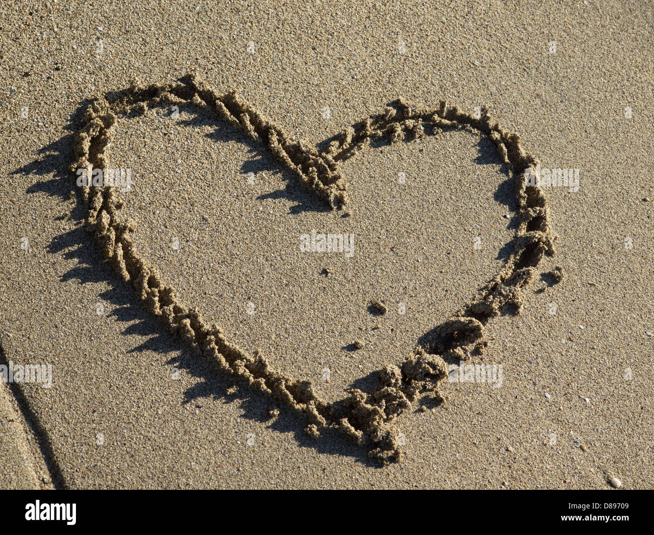 A heart shape drawn in the sand Stock Photo - Alamy