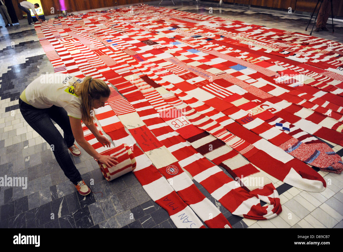 An employee of the Bavarian broadcast (Bayerischer Rundfunk) winds a scarf in the house of the Bayerischer Rundfunk in Munich, Germany, 22 May 2013. Fans of FC Bayern Munich work on an oversize fan scarf for the Champions League finale. The radio channel Bayern 3 (Bavaria 3) called for the 'Scarf of the south' ('Schal des Südens'). Fans sent more than 1.000 packages with an estimated overall scarf length of more than one km until Tuesday. Photo: Andreas Gebert Stock Photo