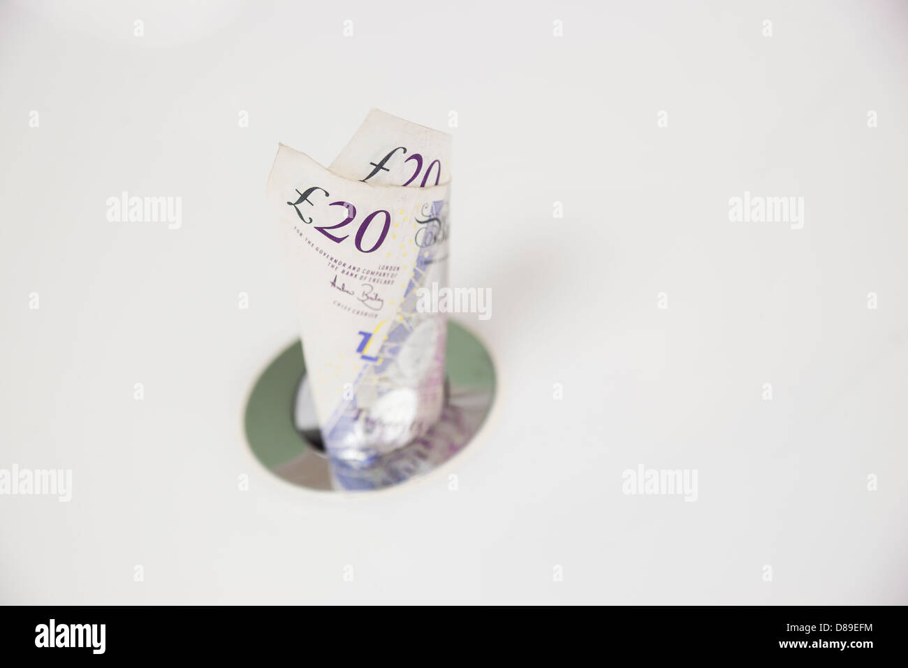 Throwing money down the drain Stock Photo Alamy