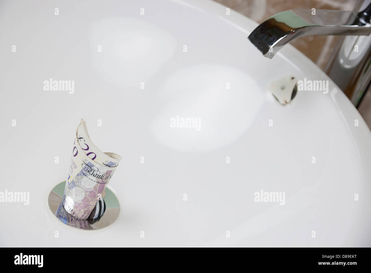 Throwing money down the drain Stock Photo Alamy