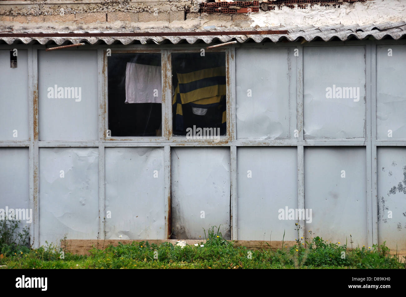 Rusty warehouse tin shack and window with drying clothes Stock Photo ...