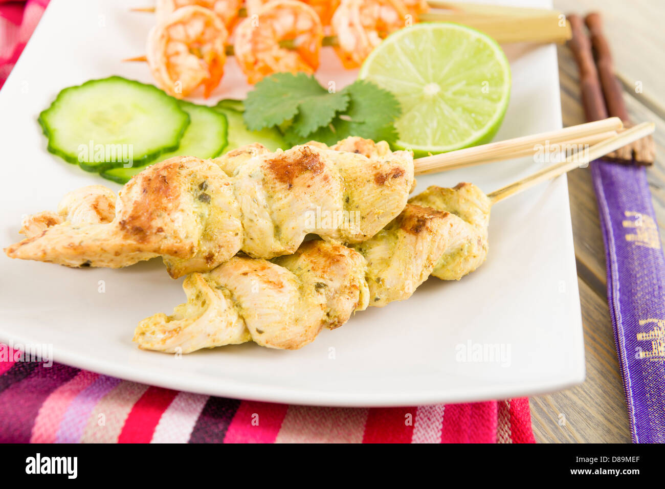 Sate Gai & Sate Goong - Thai chicken and prawn satays served with cucumber and onion relish and peanut sauce. Stock Photo