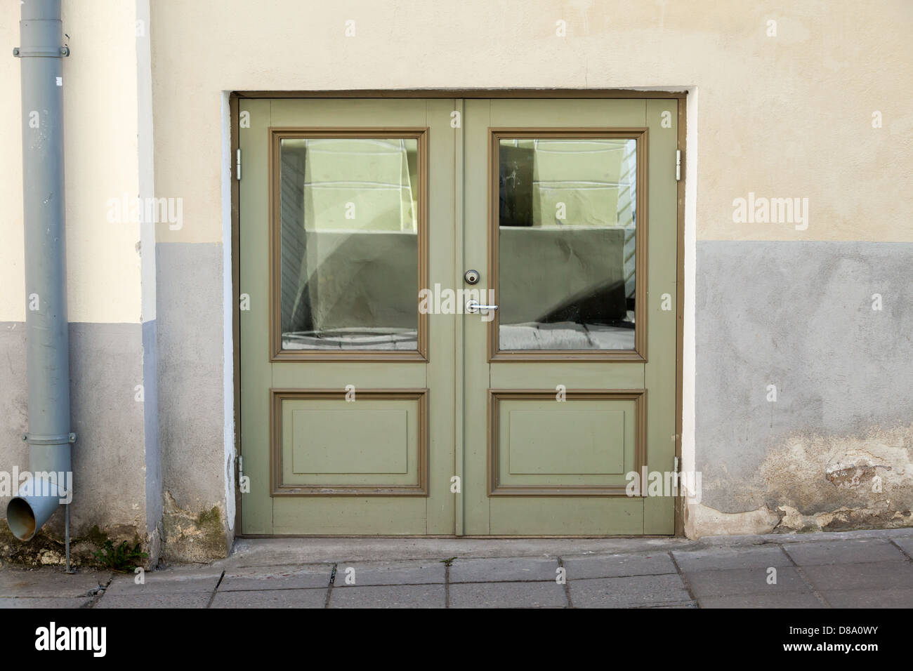 Green double door with decoration elements in old building facade. Tallinn, Estonia Stock Photo
