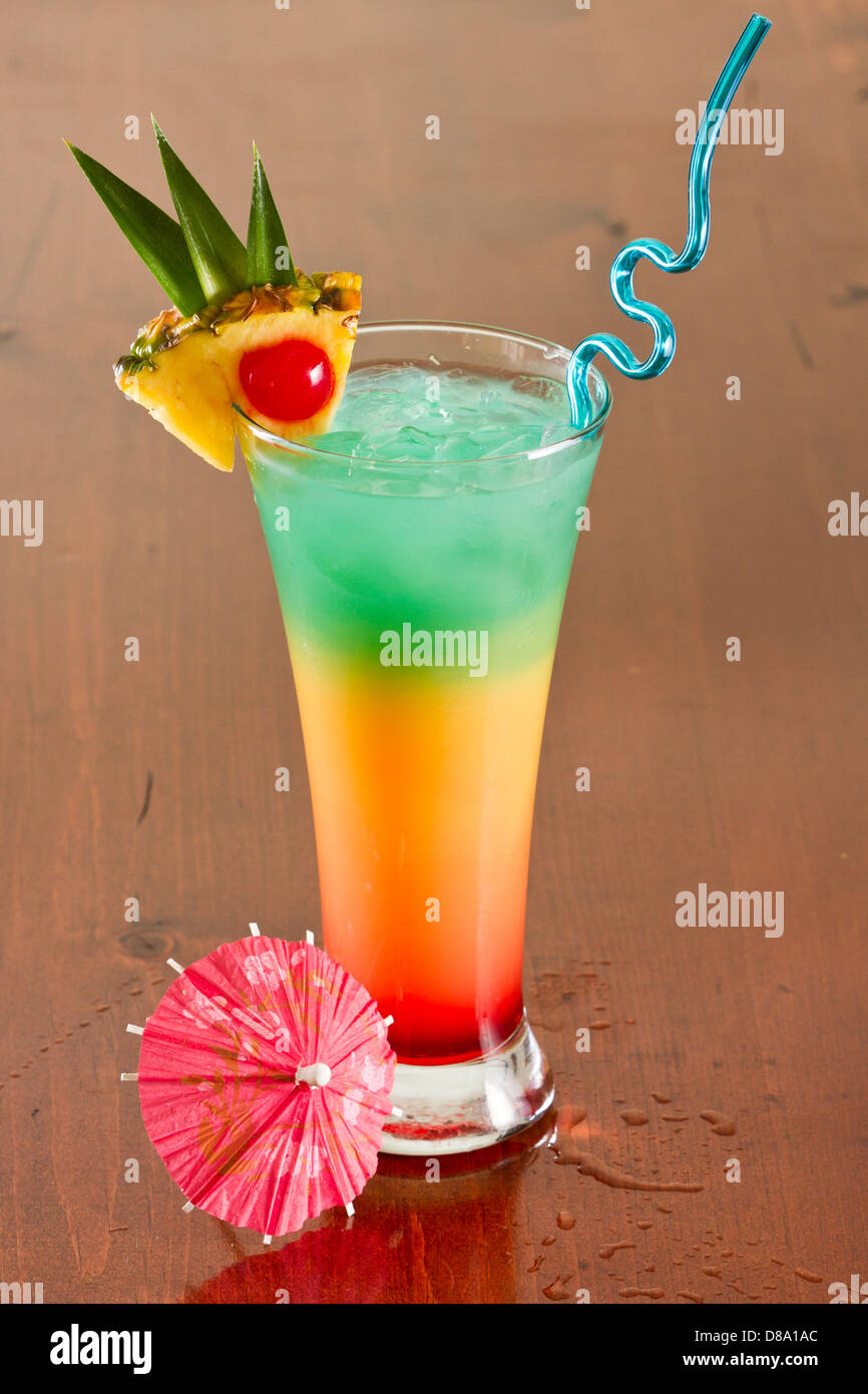 colorful tropical cocktail with layers and fruit garnishes Stock Photo