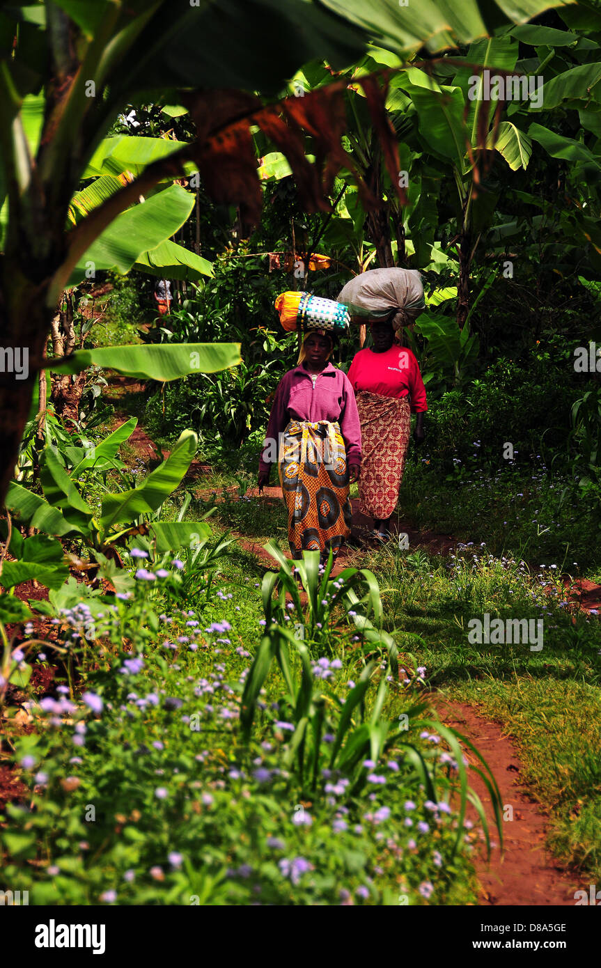 Two Woman Carrying sacks on their head while going to the market to sell goods. Marangu village, Tanzania. Stock Photo