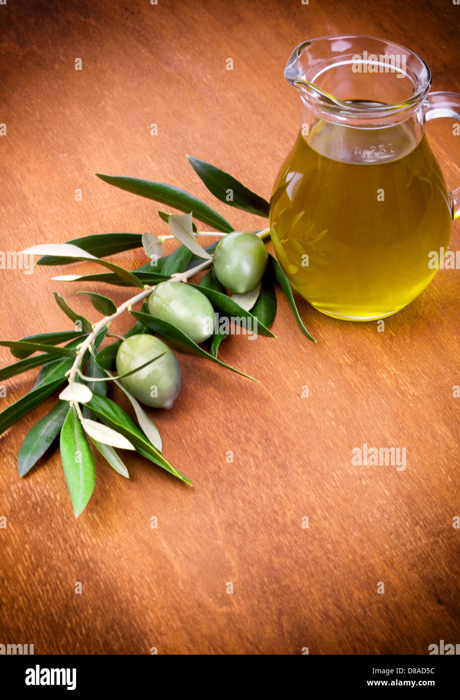 Olives and a bottle of olive oil isolated on wooden table Stock Photo Alamy