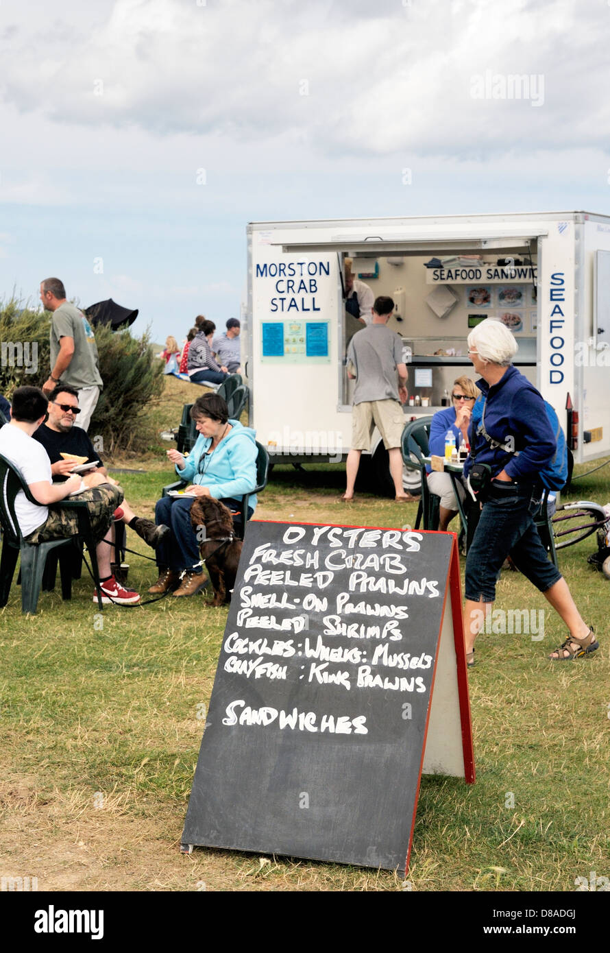 Visitors to Morston Harbour and Blakeney National Nature Reserve enjoy local seafood at Morston, Norfolk, England Stock Photo