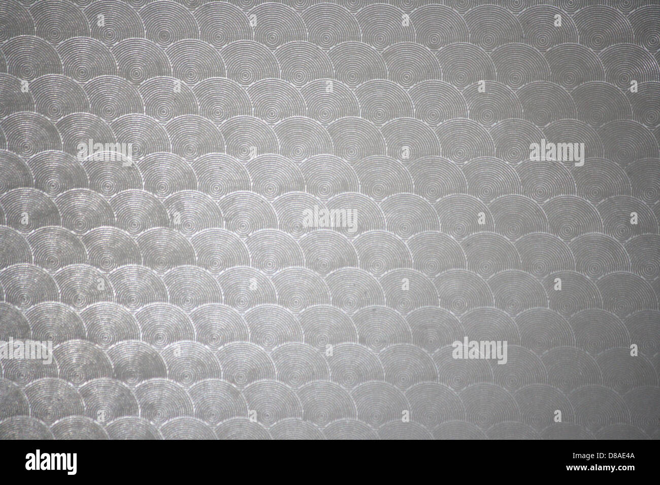 A close-up of gray plastic with a circular patterned texture. The ...