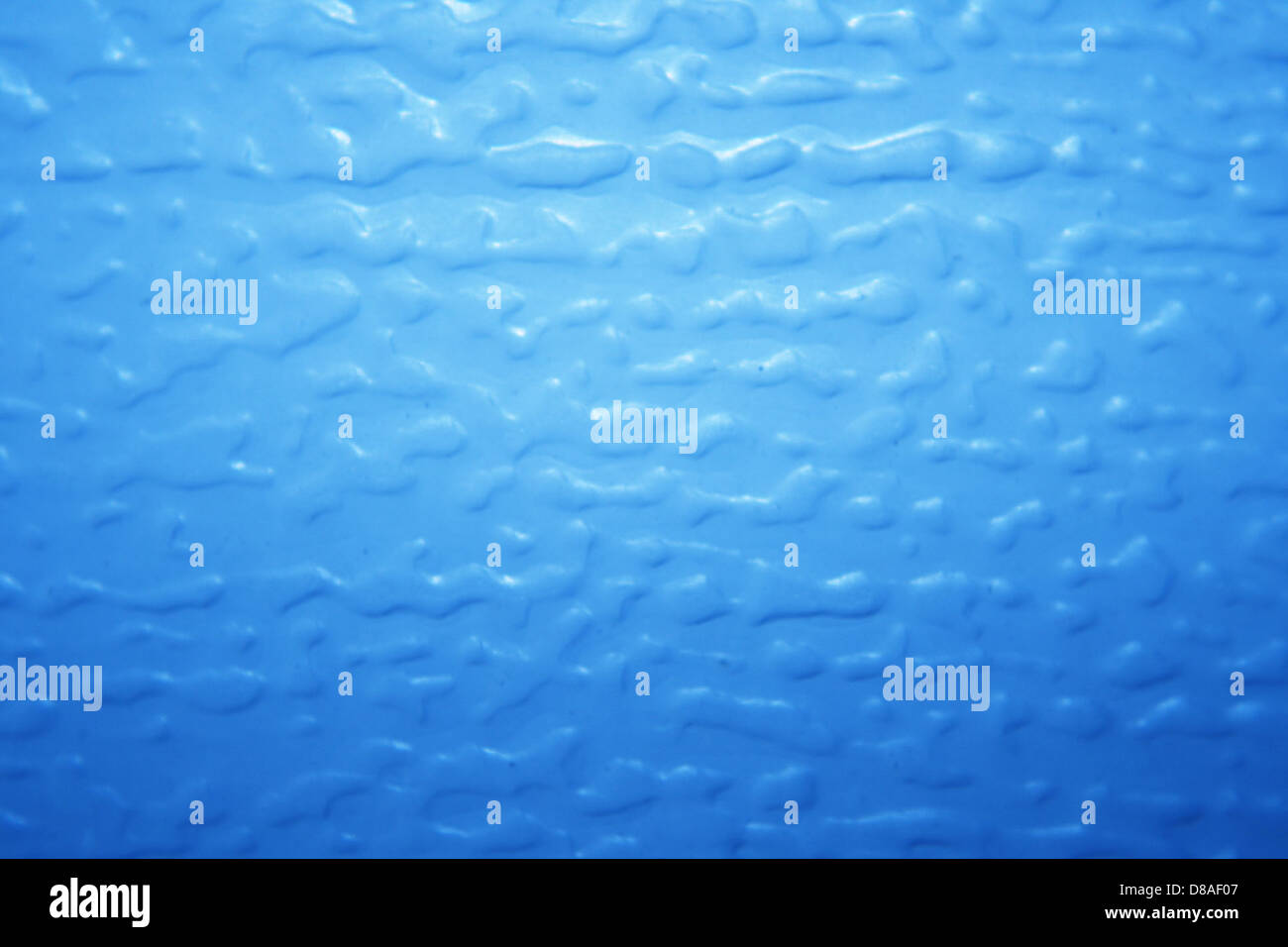 Close-up of a light blue plastic surface with a bumpy texture ...